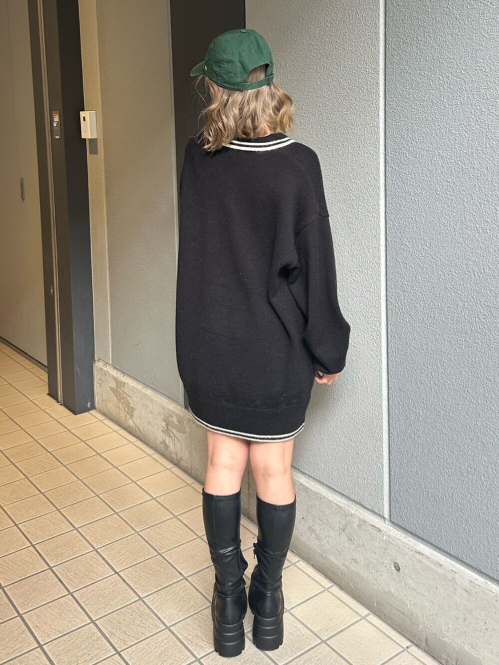 ブラック系のブーツ、ブルー系のデニムスカート、ブラック系のニット/セーターを着用したレディースの冬コーディネートの3枚目の写真