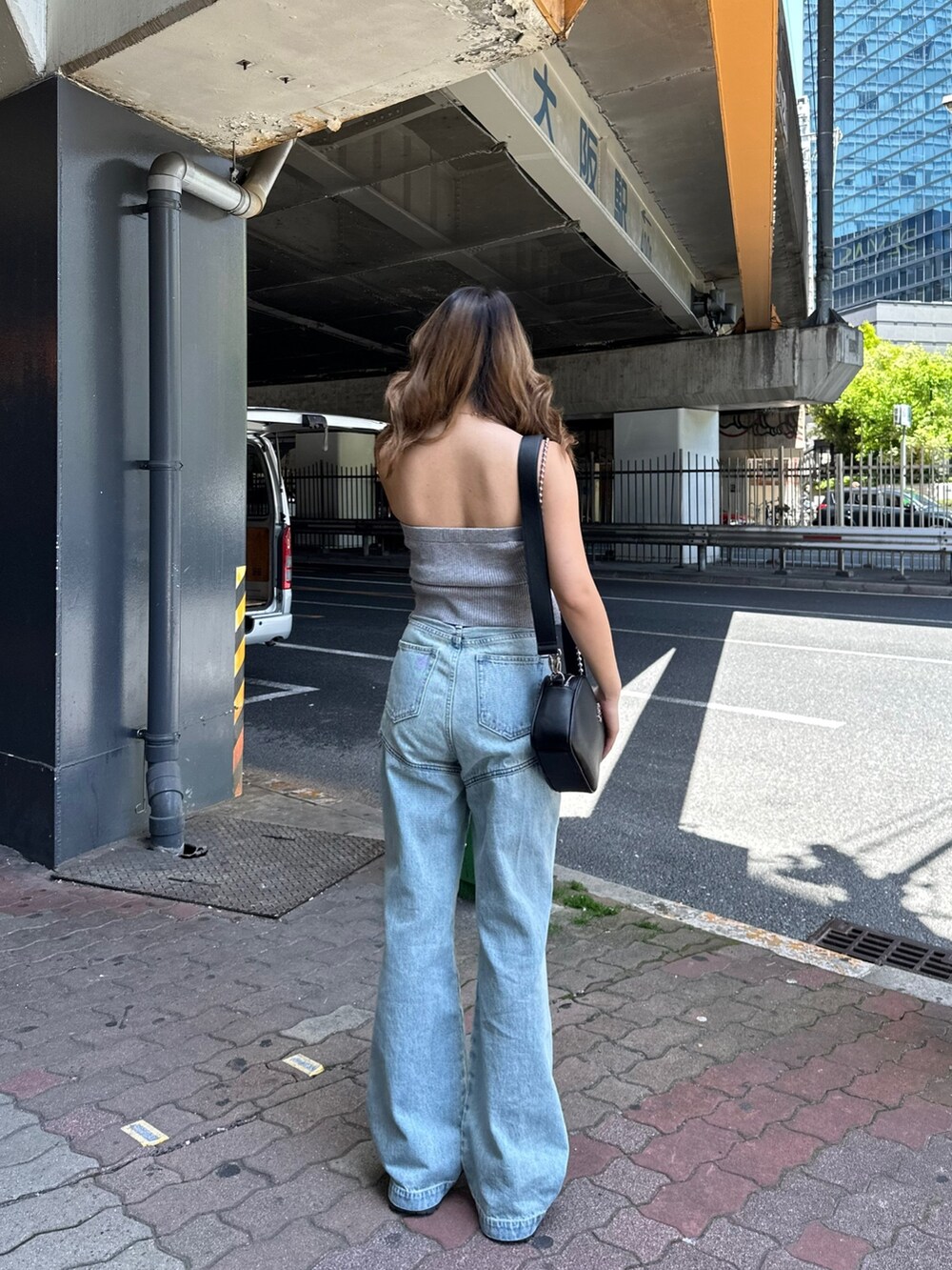 ブラック系のサンダル、ブラック系のショルダーバッグ、グレー系のチューブトップを着用したレディースの春コーディネートの3枚目の写真