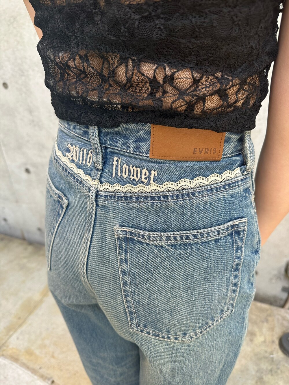 ブルー系のデニムパンツ、ブラウン系のブーツ、ブラック系のTシャツ/カットソーを着用したレディースの春コーディネートの7枚目の写真