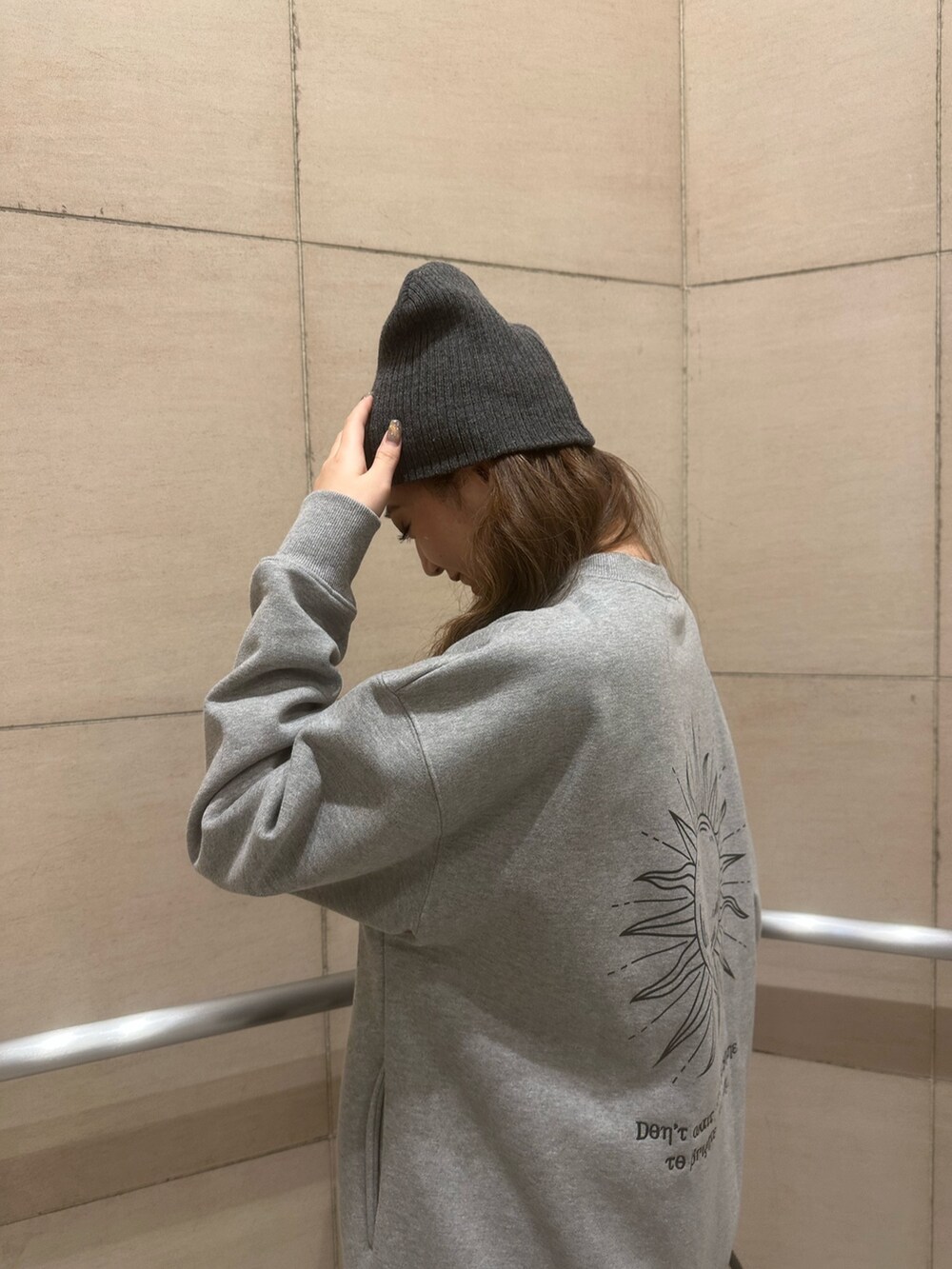 グレー系のスウェット、ブラック系のブルゾン、ブラック系のハンドバッグを着用したレディースの冬コーディネートの4枚目の写真