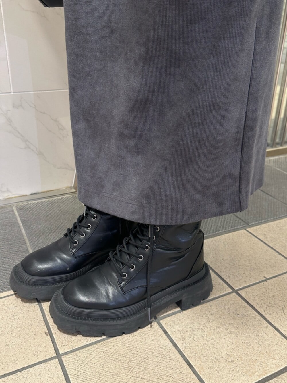 ブラック系のブーツ、ブラック系のスカート、ブラック系のショルダーバッグを着用したレディースの冬コーディネートの10枚目の写真