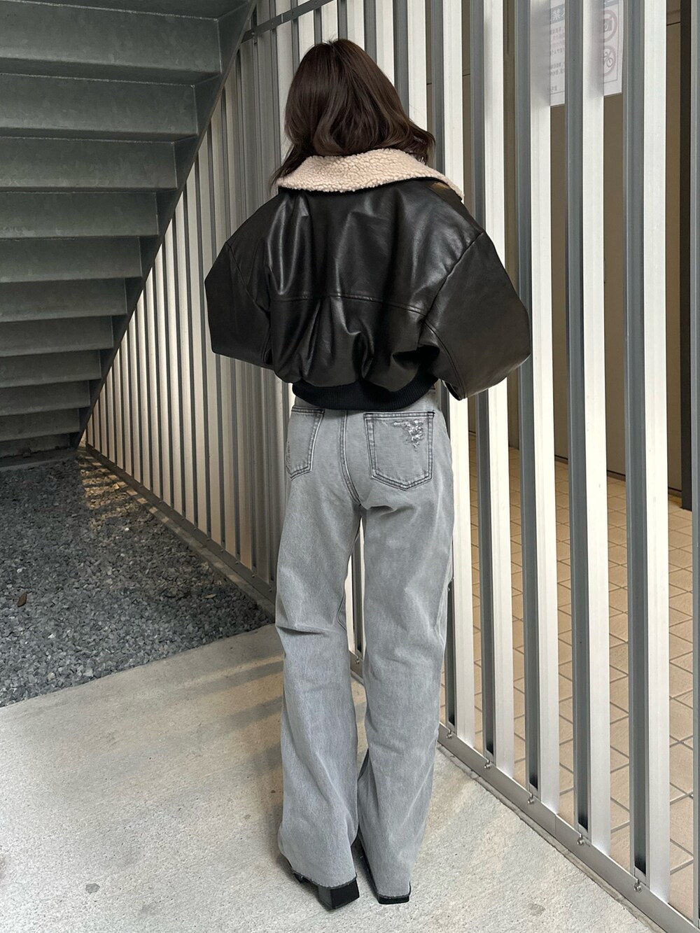 ブラック系のデニムパンツ、ブラック系のブルゾン、ブラック系のTシャツ/カットソーを着用したレディースの冬コーディネートの4枚目の写真