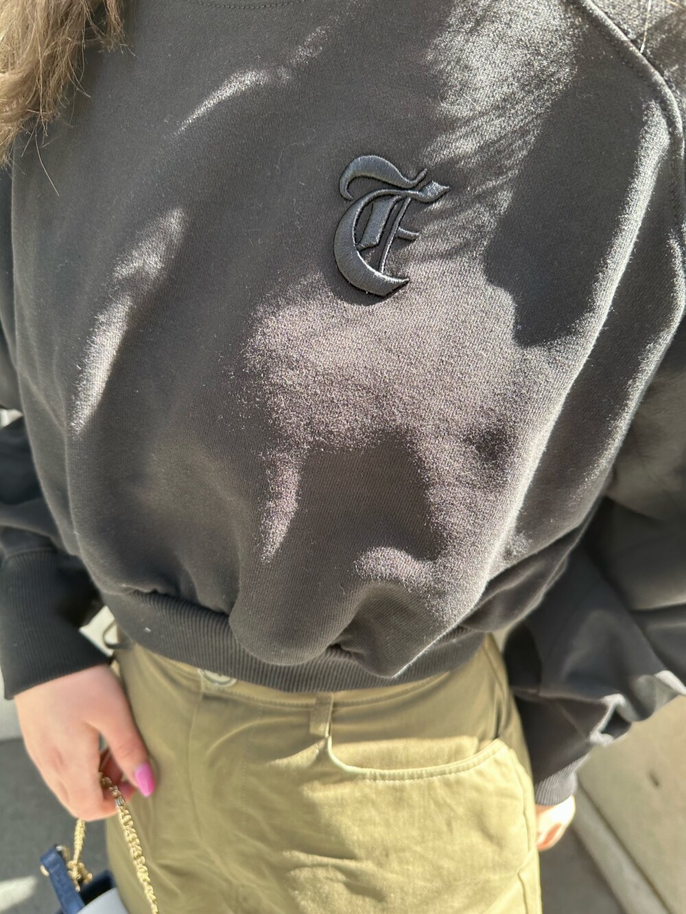 ブラック系のスウェット、ブラック系のブーツ、ブルー系のショルダーバッグを着用したレディースの冬コーディネートの4枚目の写真