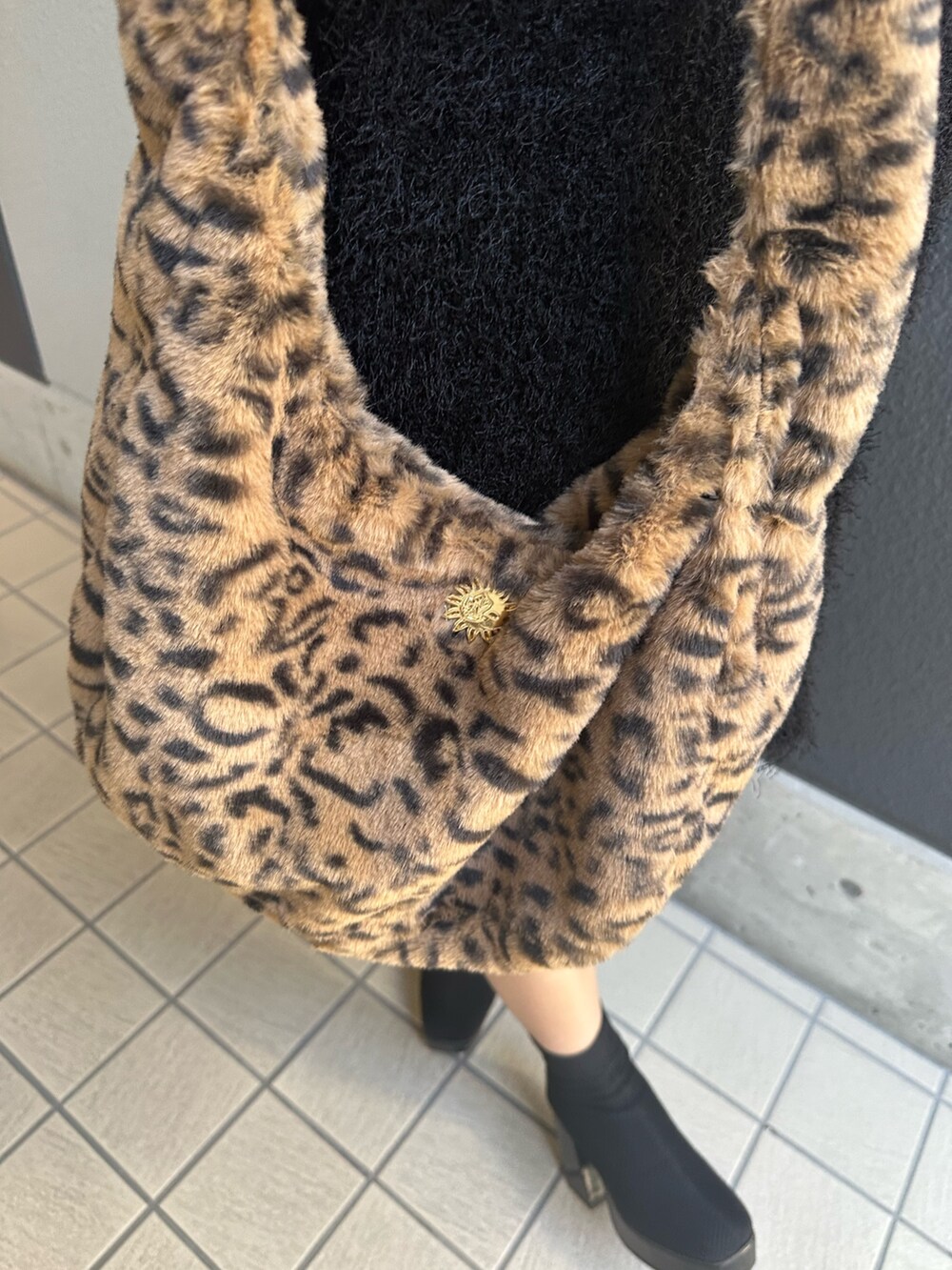 その他のブーツ、ブラック系のニット/セーター、その他のショルダーバッグを着用したレディースの秋コーディネートの6枚目の写真