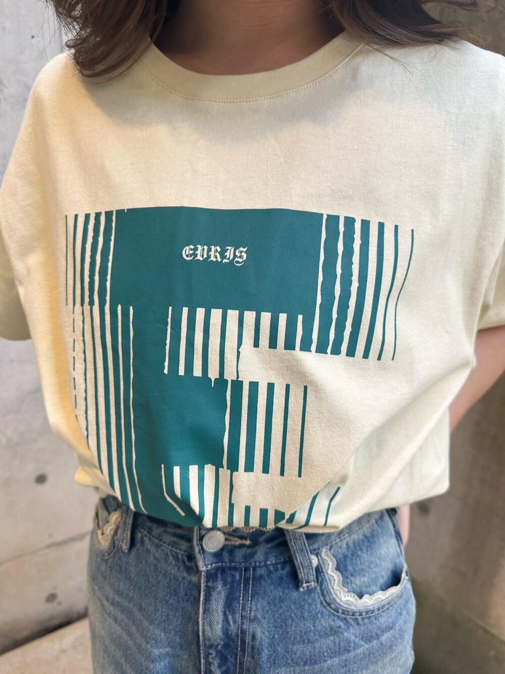 イエロー系のTシャツ/カットソー、ブルー系のデニムパンツ、ブラウン系のブーツを着用したレディースの春コーディネートの5枚目の写真