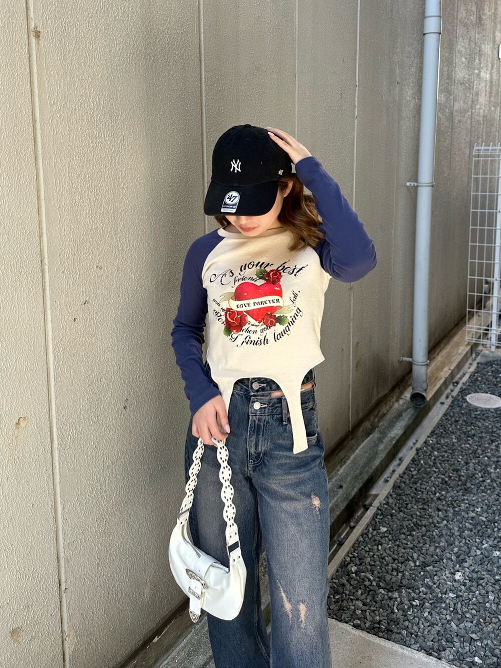 ブルー系のTシャツ/カットソー、ホワイト系のショルダーバッグ、ブルー系のデニムパンツを着用したレディースの春コーディネートの5枚目の写真