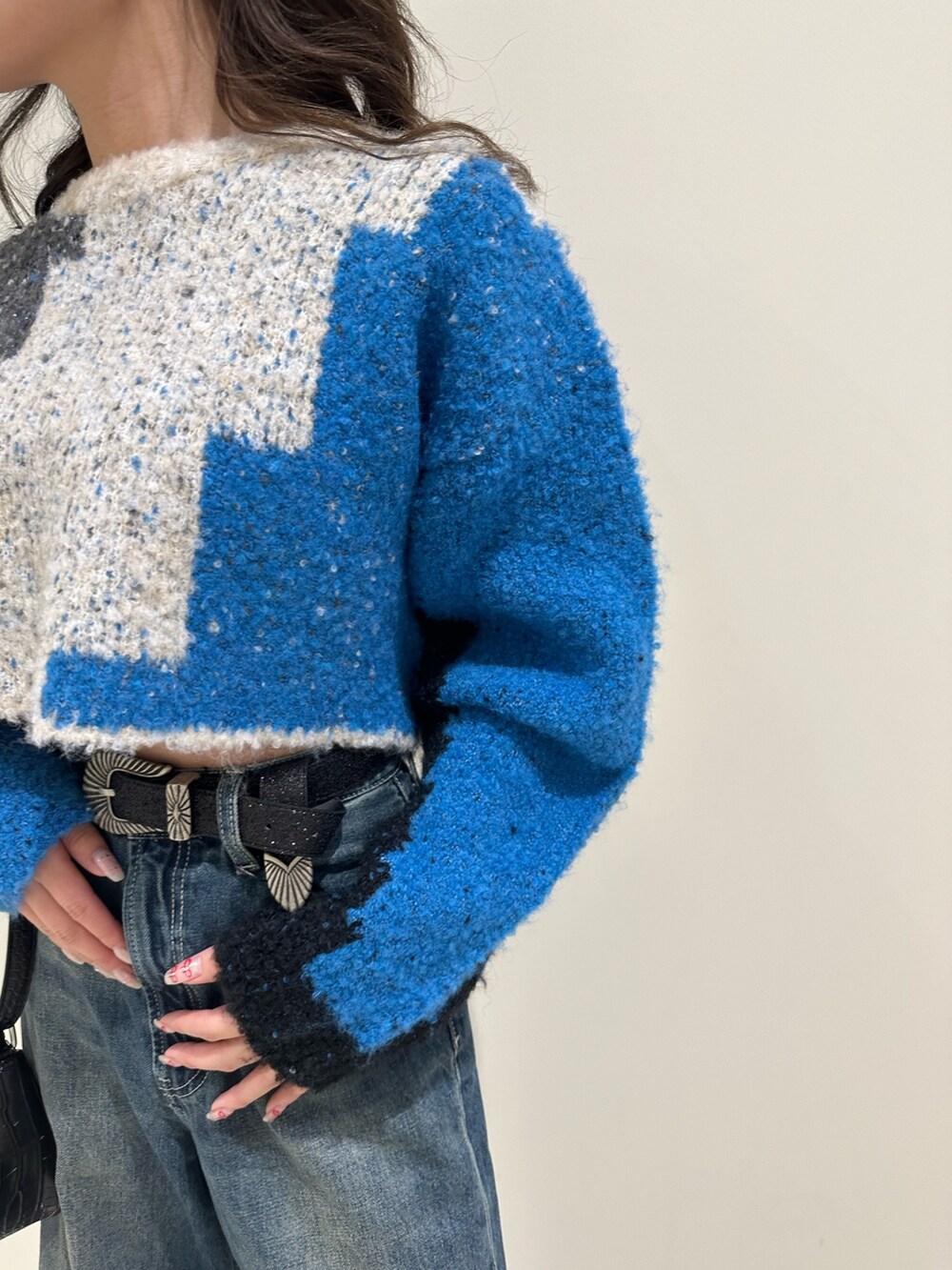 ブルー系のデニムパンツ、ブラック系のショルダーバッグ、ブラック系のブーツを着用したレディースの冬コーディネートの6枚目の写真