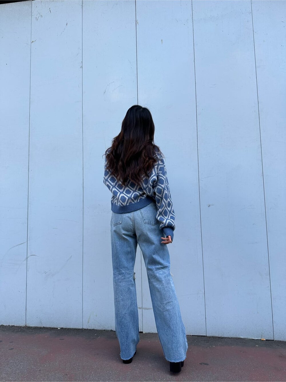 ブラック系のブーツ、ブルー系のニット/セーター、ブルー系のデニムパンツを着用したレディースの秋コーディネートの4枚目の写真