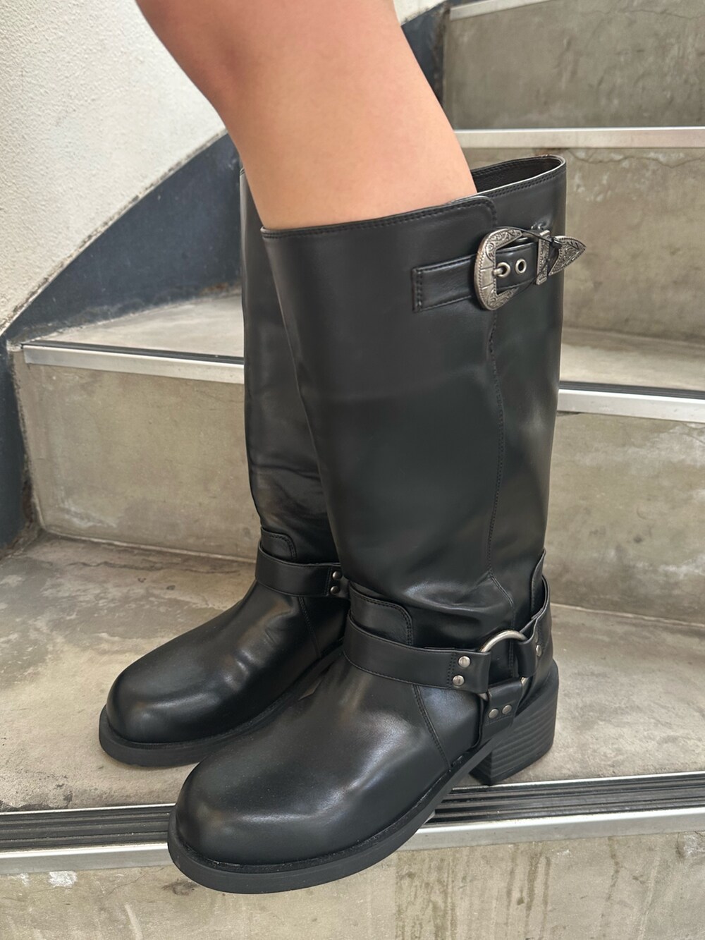 ブルー系のデニムスカート、ブラック系のブーツ、ブラック系のブルゾンを着用したレディースの冬コーディネートの8枚目の写真