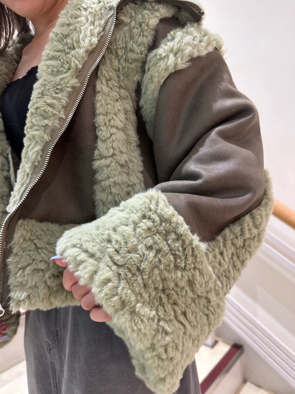 ブラック系のニット/セーター、ブラック系のデニムスカート、ブラック系のブーツを着用したレディースの夏コーディネートの6枚目の写真