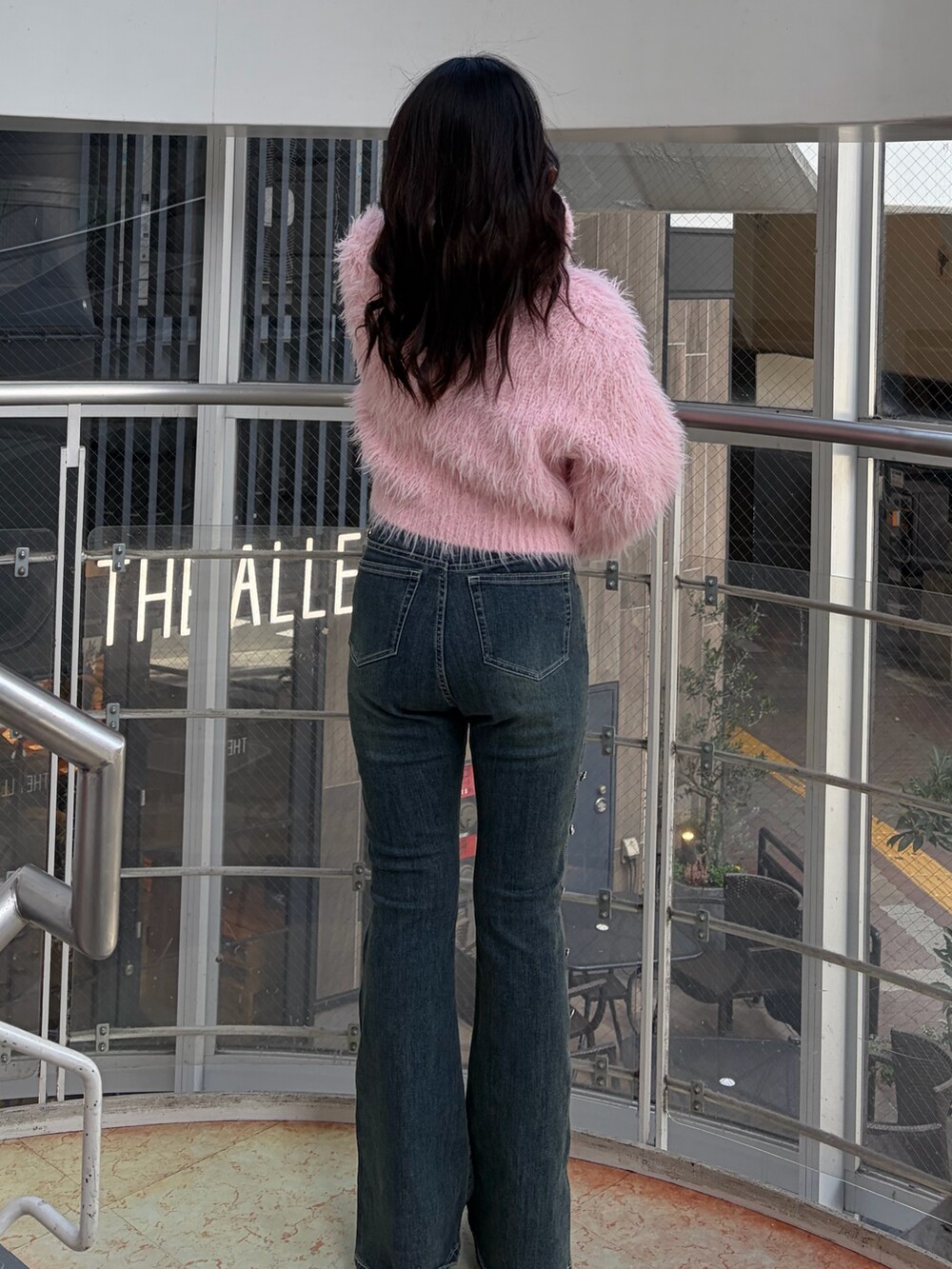 ブルー系のデニムパンツ、ピンク系のニット/セーター、ブラック系のブーツを着用したレディースの冬コーディネートの5枚目の写真