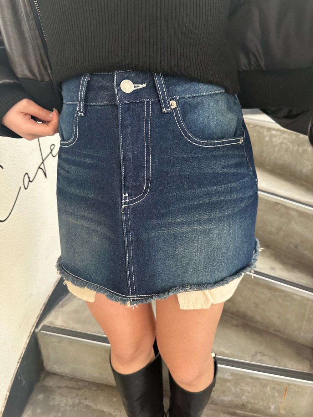 ブルー系のデニムスカート、ブラック系のブーツ、ブラック系のブルゾンを着用したレディースの冬コーディネートの7枚目の写真