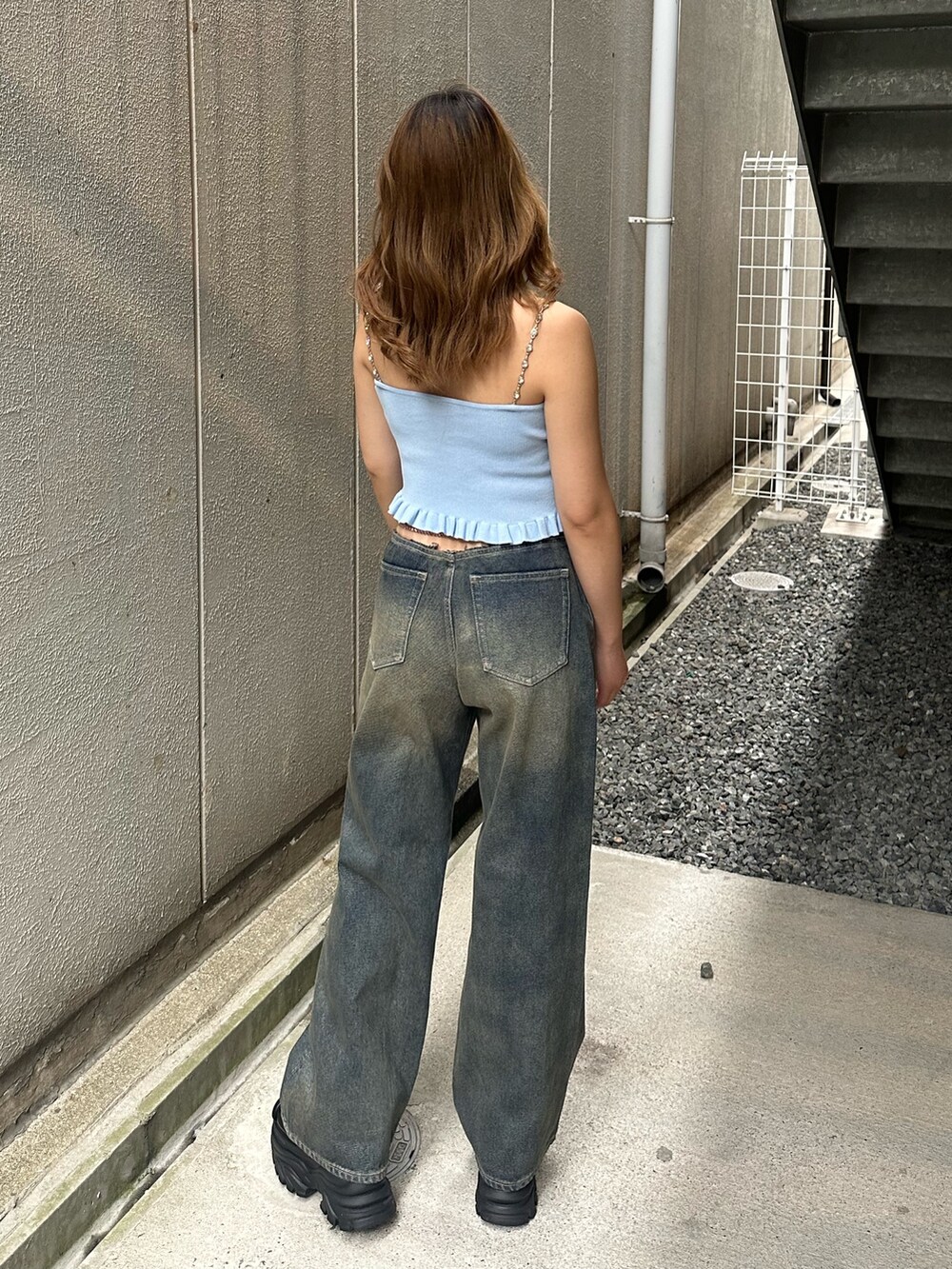 ブルー系のデニムパンツ、ブラック系のサンダル、ブルー系のキャミソールを着用したレディースの夏コーディネートの3枚目の写真