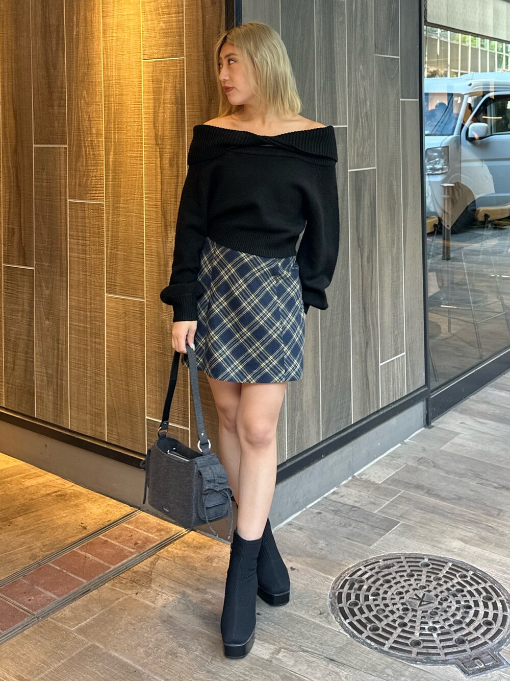 ブラック系のニット/セーター、その他のブーツ、ブラック系のハンドバッグを着用したレディースの秋コーディネートの2枚目の写真