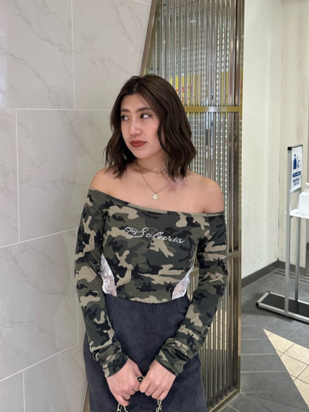 ブラック系のブーツ、ブラック系のスカート、ブラック系のショルダーバッグを着用したレディースの冬コーディネートの4枚目の写真