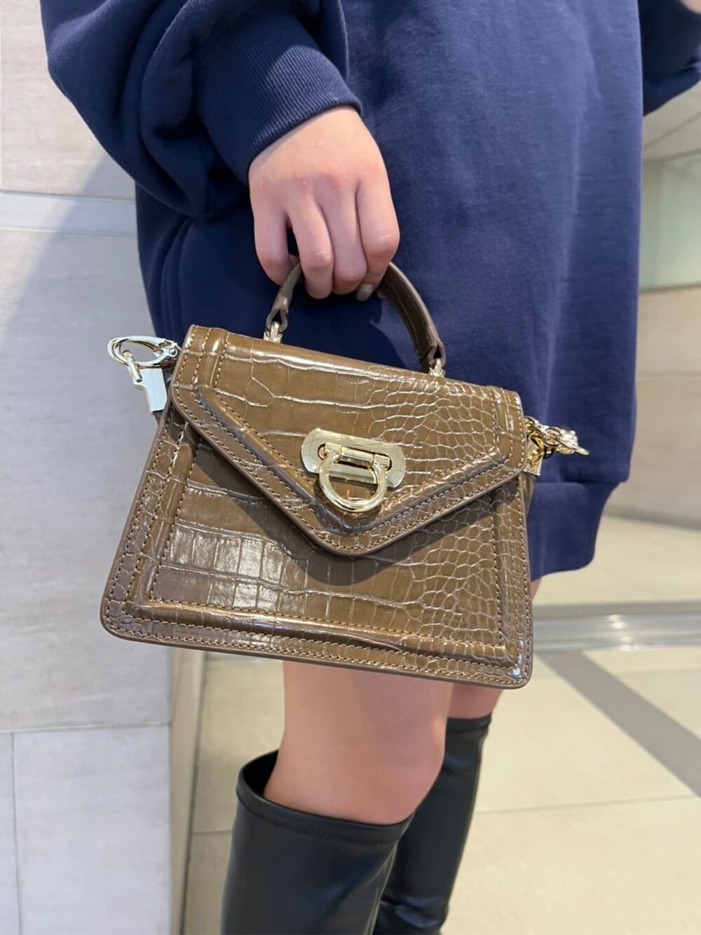 ブラック系のブーツ、ブラウン系のハンドバッグ、ブルー系のパーカーを着用したレディースの秋コーディネートの6枚目の写真