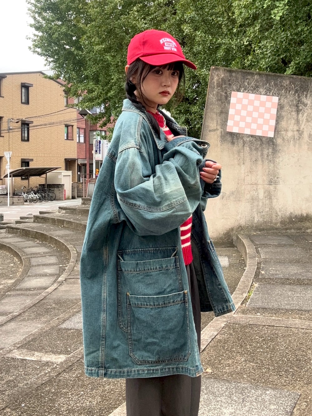 ベージュ系のスラックス、ブラック系のシューズ、ホワイト系のバッグを着用したレディースの春コーディネートの2枚目の写真