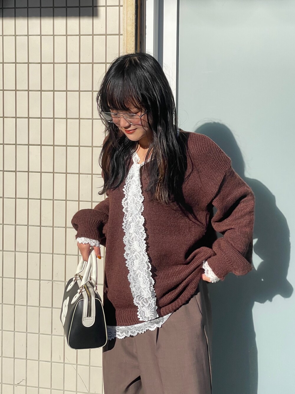 ブラウン系のニット/セーター、ブラウン系のその他パンツ、ブラック系のボストンバッグを着用したレディースの冬コーディネートの2枚目の写真