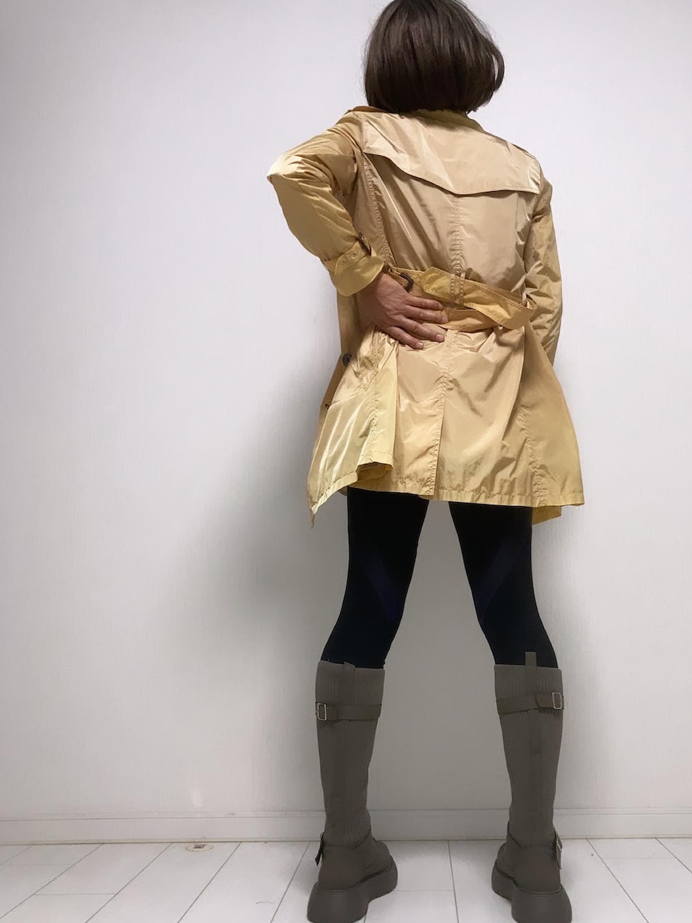 ピンク系のポロシャツ、ベージュ系のトレンチコート、ベージュ系のスカートを着用したレディースの秋コーディネートの2枚目の写真