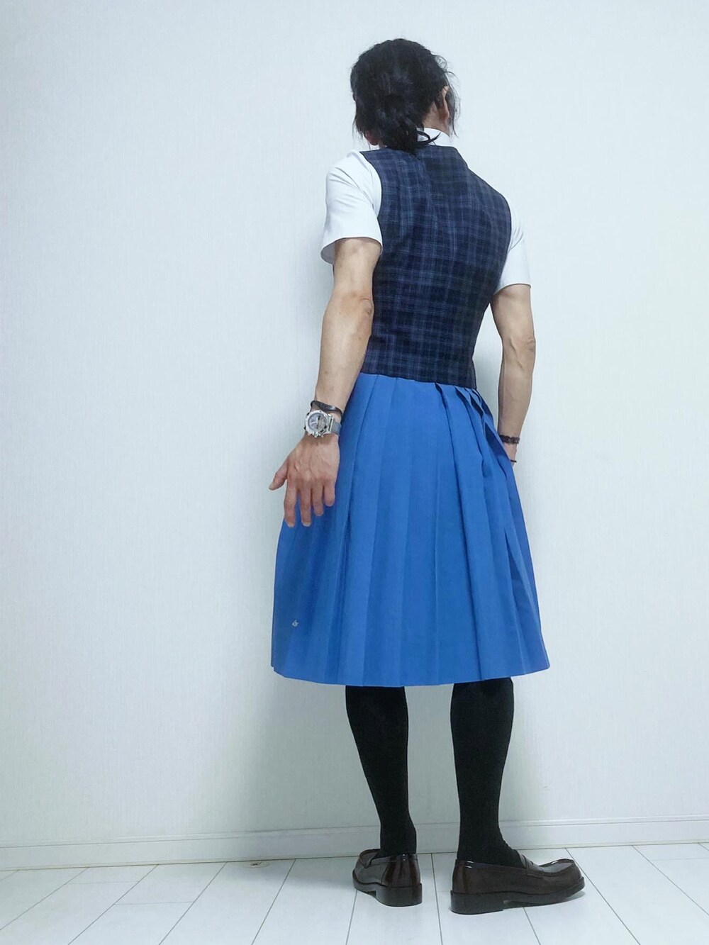 ブラック系のローファー、ブルー系のジャンパースカート、ブルー系のスーツベストを着用したレディースの春コーディネートの2枚目の写真