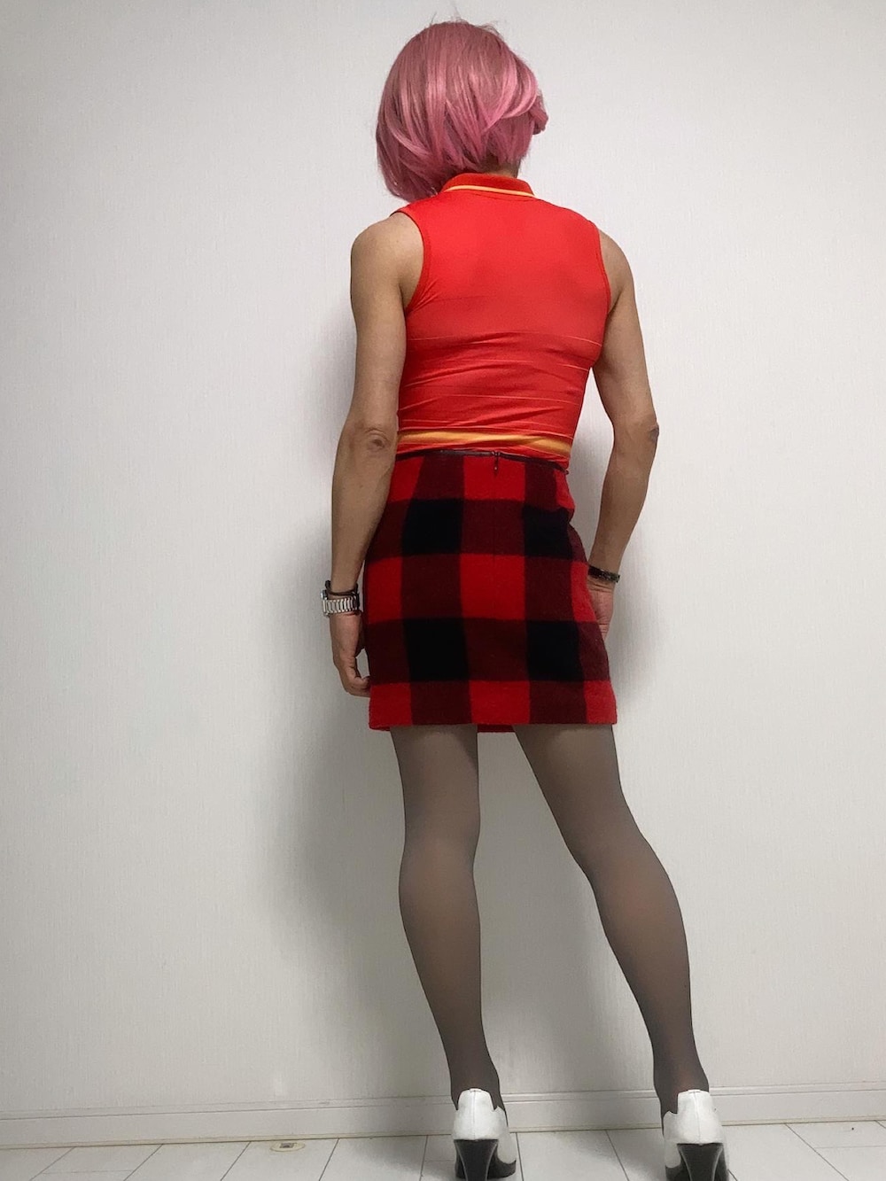 レッド系のワンピース、レッド系のスカート、ホワイト系のパンプスを着用したレディースの秋コーディネートの2枚目の写真