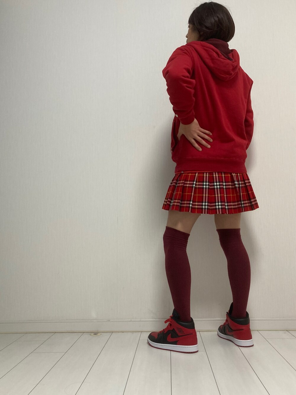 レッド系のパーカー、レッド系のスカート、レッド系のスニーカーを着用したレディースの冬コーディネートの2枚目の写真