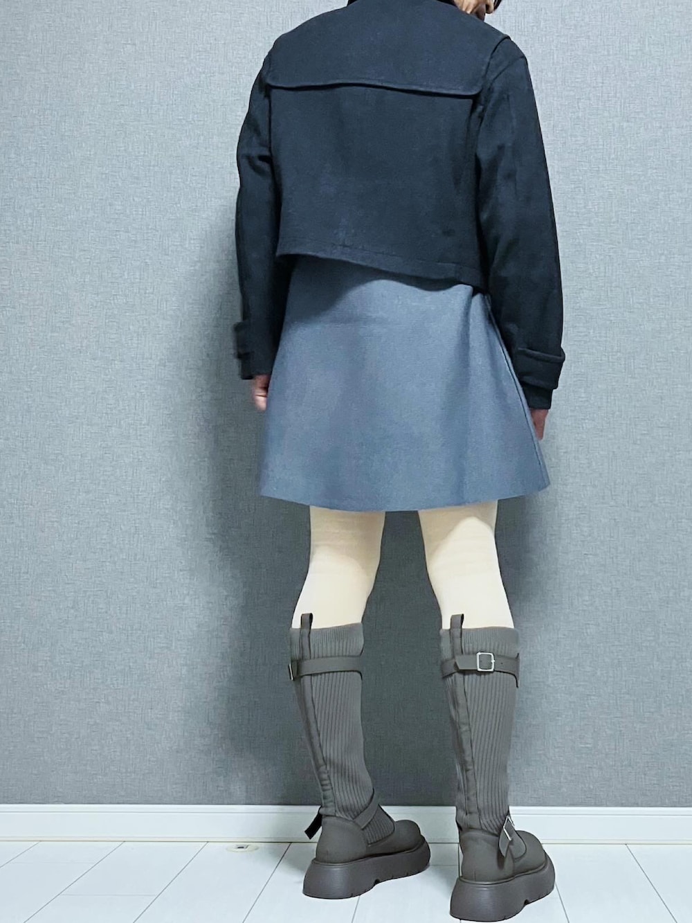 グレー系のブーツ、グレー系のワンピース、グレー系のダッフルコートを着用したレディースの秋コーディネートの2枚目の写真