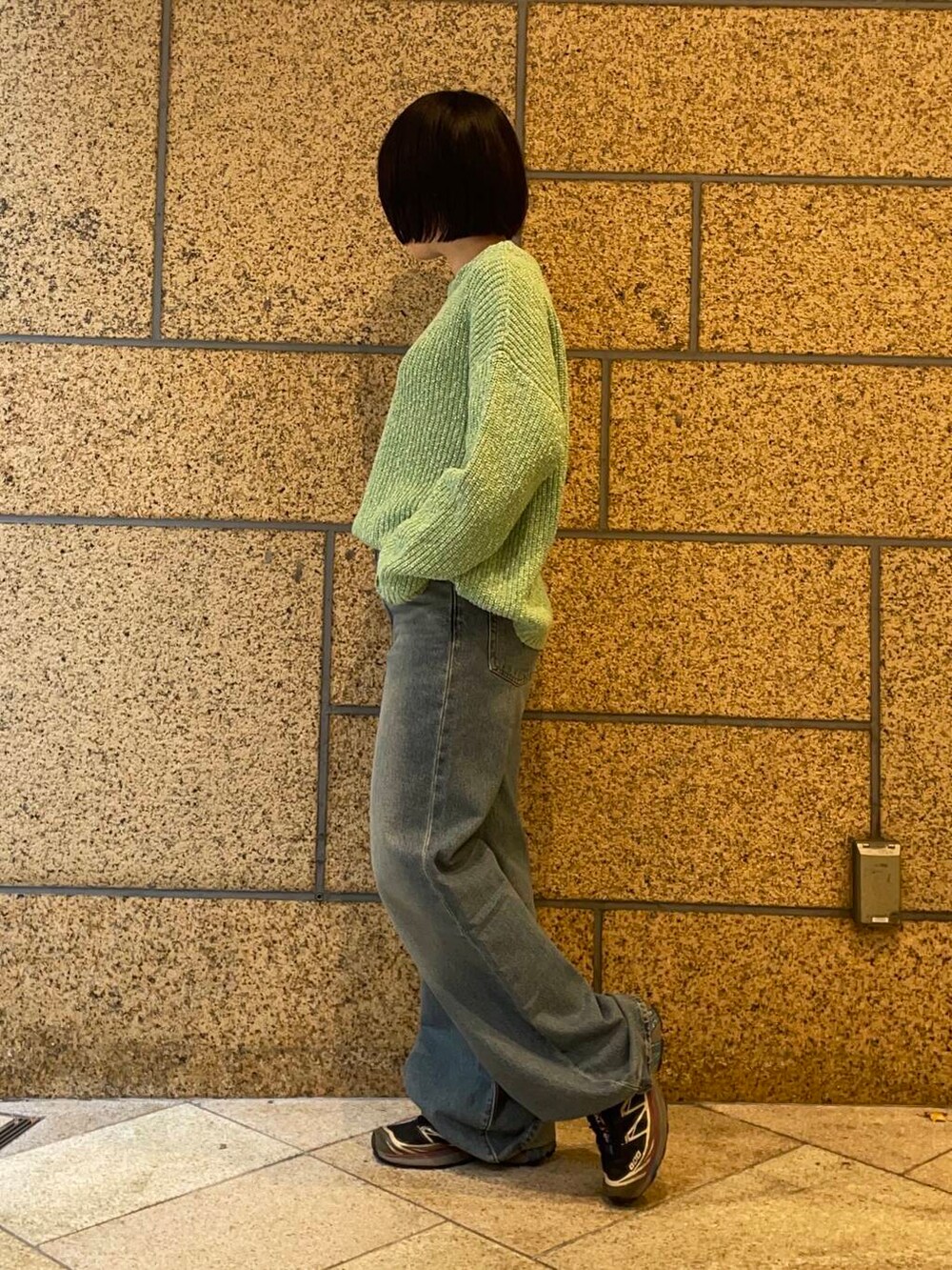 グリーン系のニット/セーターを着用したレディースの冬コーディネートの2枚目の写真