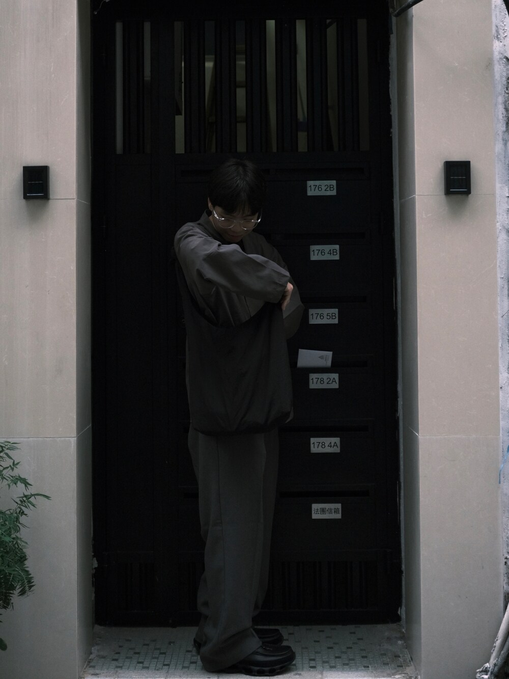 グレー系のその他アウター、ブラック系のスニーカー、ブルー系の福袋/福箱を着用したメンズの秋コーディネートの2枚目の写真