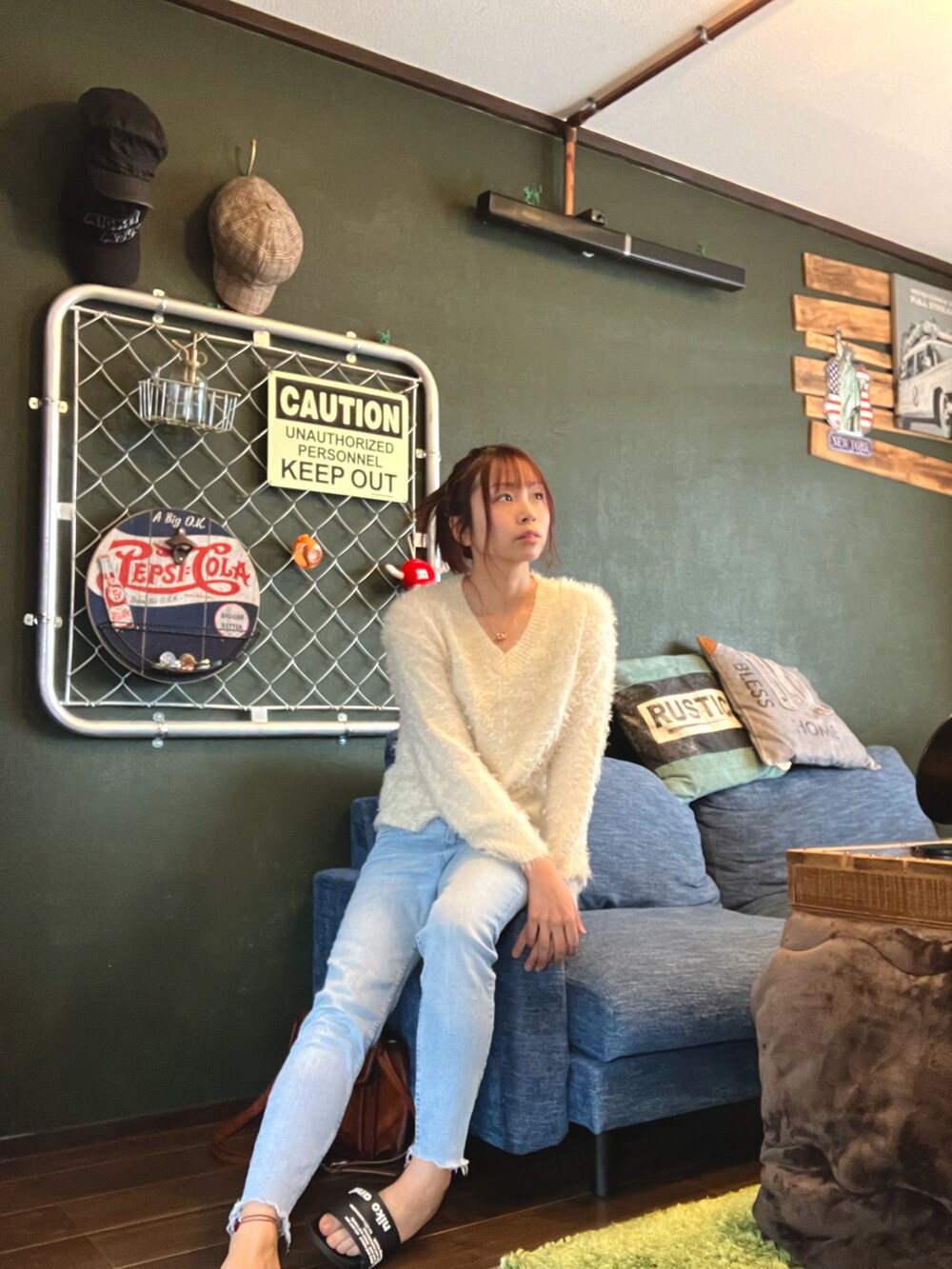 ブルー系のデニムパンツ、ホワイト系のニット/セーター、ゴールド系のネックレスを着用したレディースの秋コーディネートの3枚目の写真