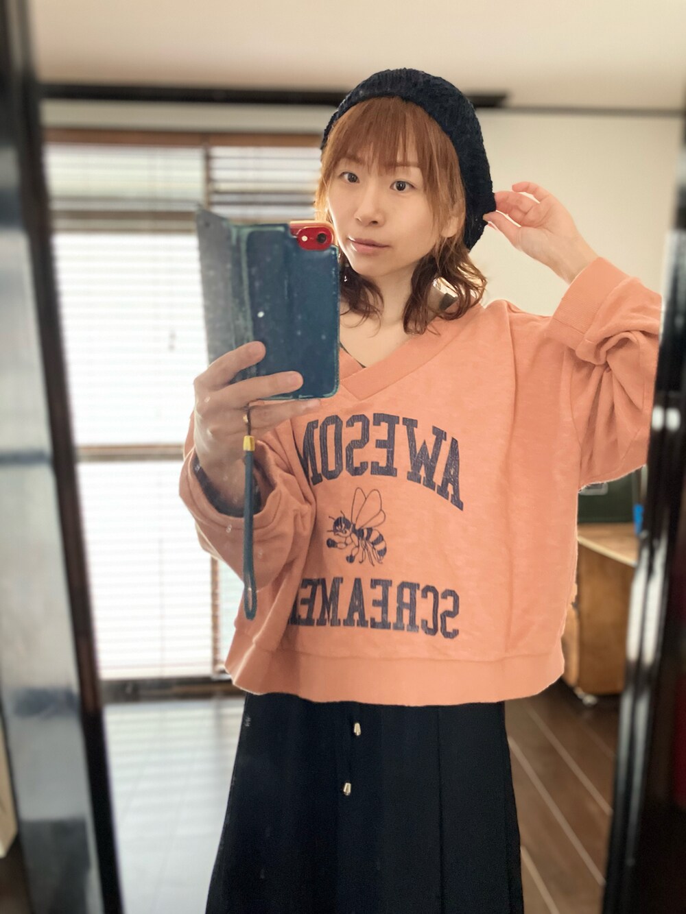 ブラック系のその他パンツ、オレンジ系のトップスを着用したレディースの春コーディネートの2枚目の写真