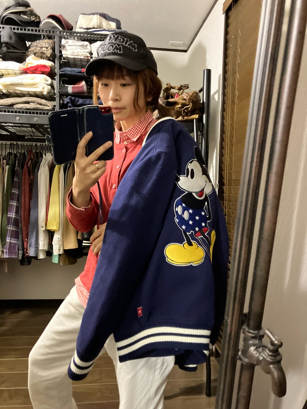 レッド系のカーディガン/ボレロ、レッド系のシャツ/ブラウス、ブルー系のスタジャンを着用したレディースの冬コーディネートの4枚目の写真