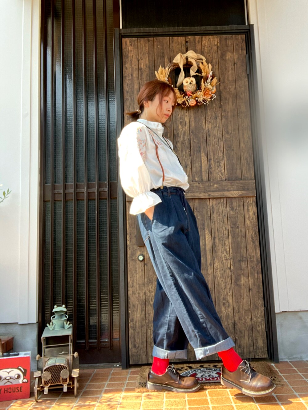 ブルー系のデニムパンツを着用したレディースの秋コーディネートの2枚目の写真