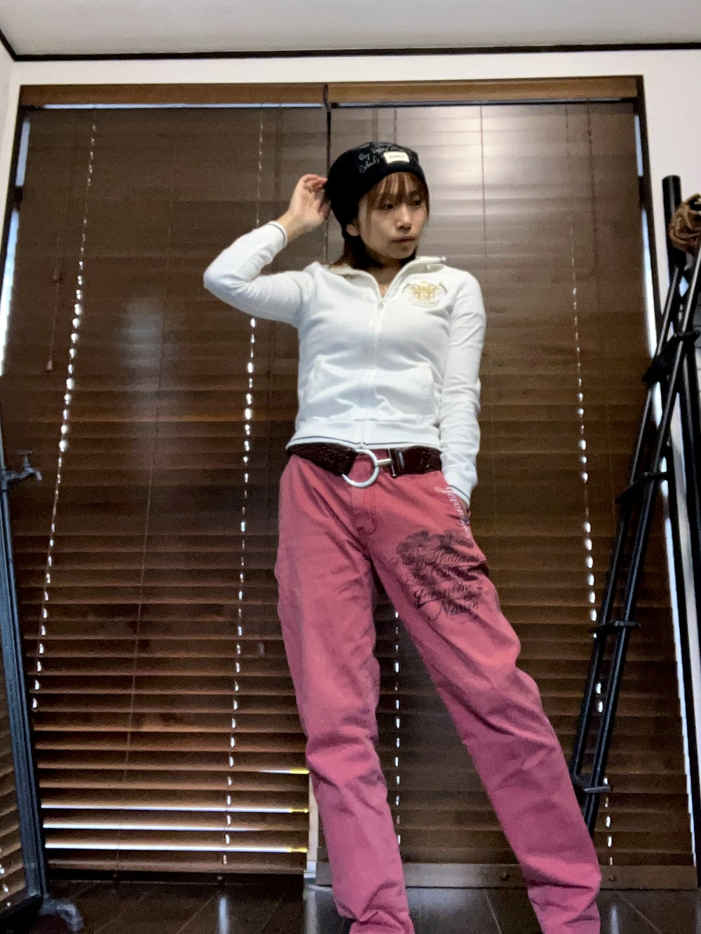 ホワイト系のパーカー、ブラック系のニットキャップ/ビーニー、ブラウン系のベルトを着用したレディースの秋コーディネートの2枚目の写真