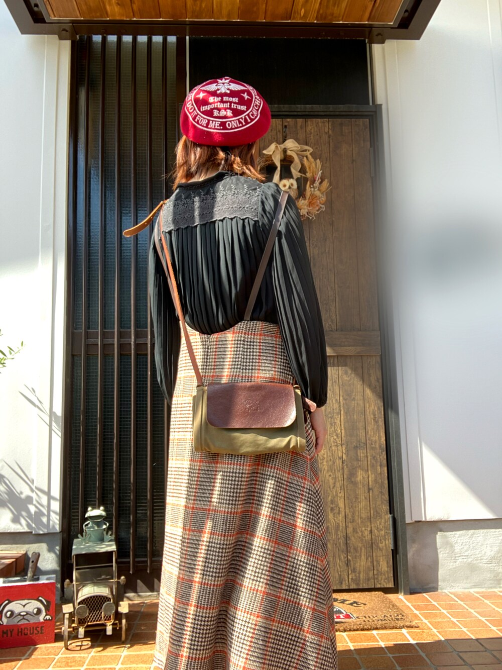 ベージュ系のワンピース、レッド系のパンプス、ブラック系のシャツ/ブラウスを着用したレディースの秋コーディネートの2枚目の写真