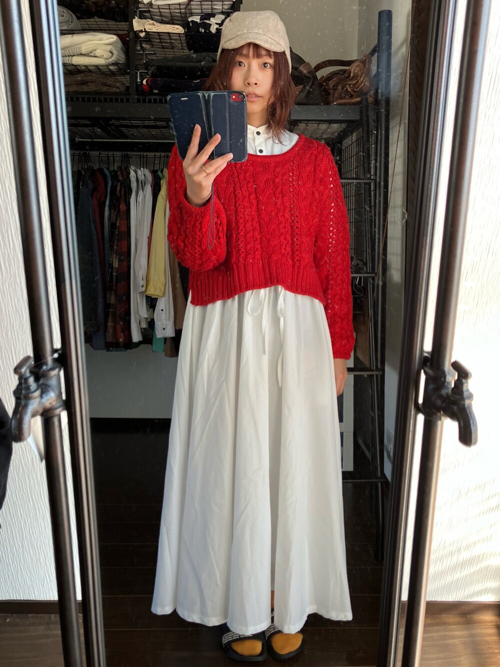レッド系のニット/セーター、ホワイト系のワンピース、ベージュ系のキャスケットを着用したレディースの冬コーディネートの5枚目の写真