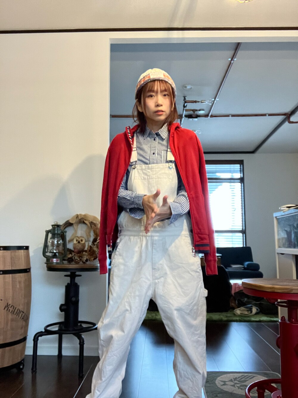 ホワイト系のサロペット/オーバーオール、ブラック系のシャツ/ブラウス、レッド系のパーカーを着用したレディースの秋コーディネートの4枚目の写真