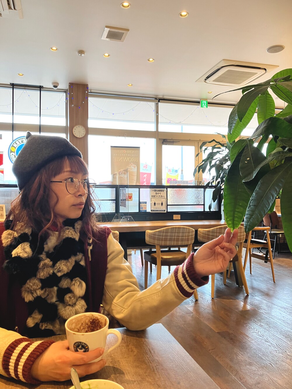 レッド系のスタジャン、グレー系の帽子を着用したレディースの冬コーディネートの2枚目の写真