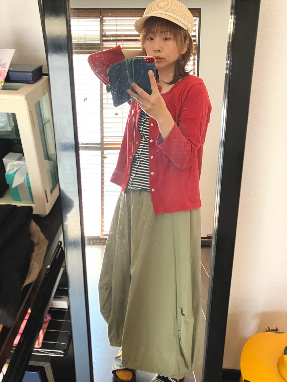 グリーン系のスカート、レッド系のカーディガン/ボレロ、ベージュ系のキャスケットを着用したレディースの春コーディネートの3枚目の写真