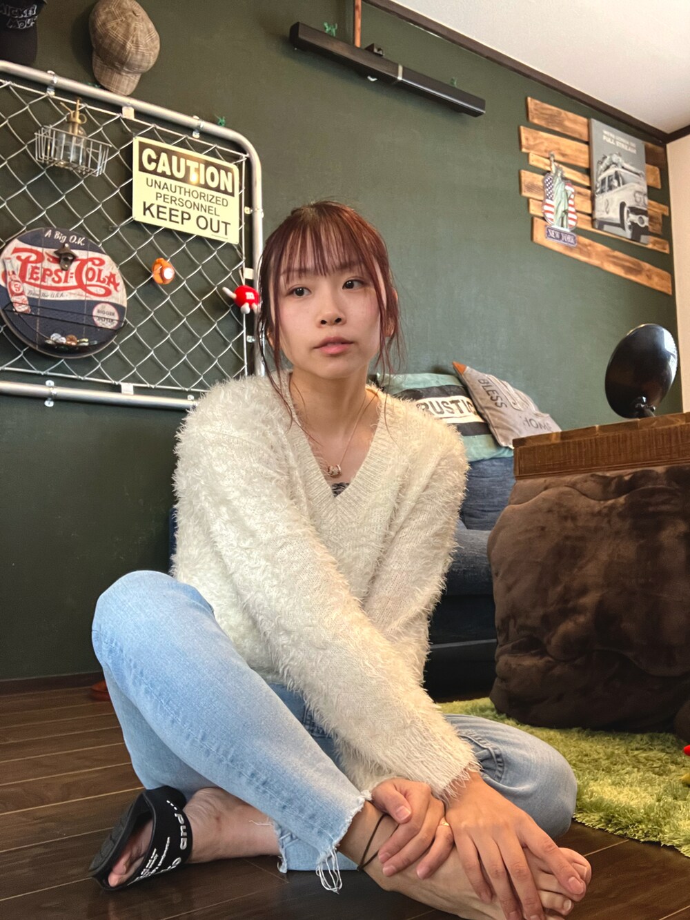 ブルー系のデニムパンツ、ホワイト系のニット/セーター、ゴールド系のネックレスを着用したレディースの秋コーディネートの2枚目の写真