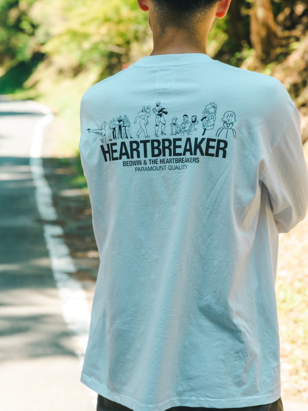 ホワイト系のTシャツ/カットソー、ブラウン系のスラックス、ブラック系のスニーカーを着用したメンズの秋コーディネートの4枚目の写真