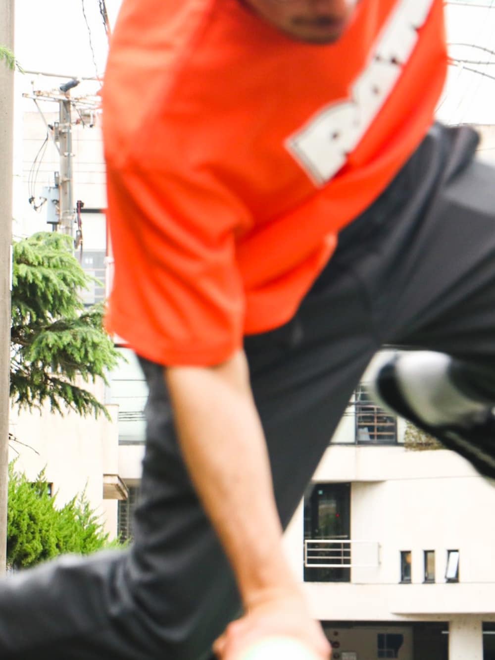 オレンジ系のTシャツ/カットソーを着用したメンズの秋コーディネートの3枚目の写真