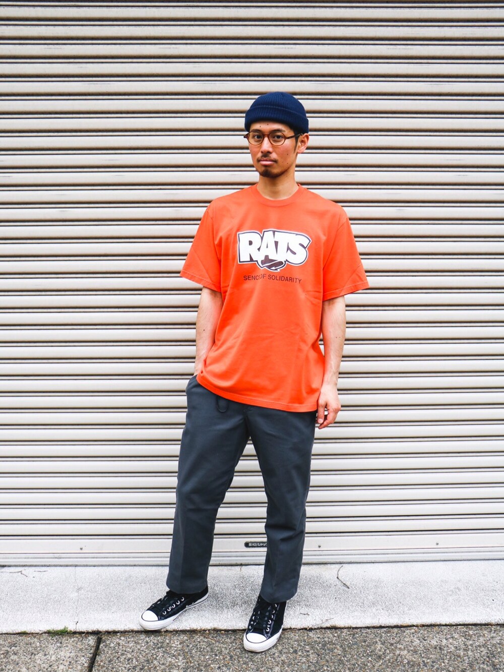 オレンジ系のTシャツ/カットソーを着用したメンズの秋コーディネートの2枚目の写真