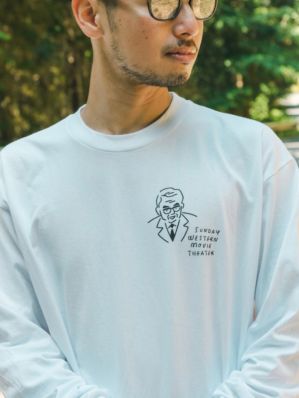 ホワイト系のTシャツ/カットソー、ブラウン系のスラックス、ブラック系のスニーカーを着用したメンズの秋コーディネートの3枚目の写真