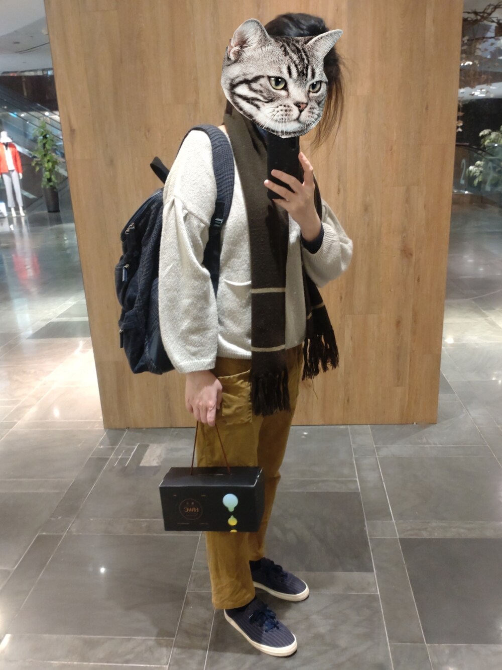 ベージュ系のニット/セーター、ブルー系のシューズ、ブラウン系のチノパンツを着用したレディースの冬コーディネートの2枚目の写真