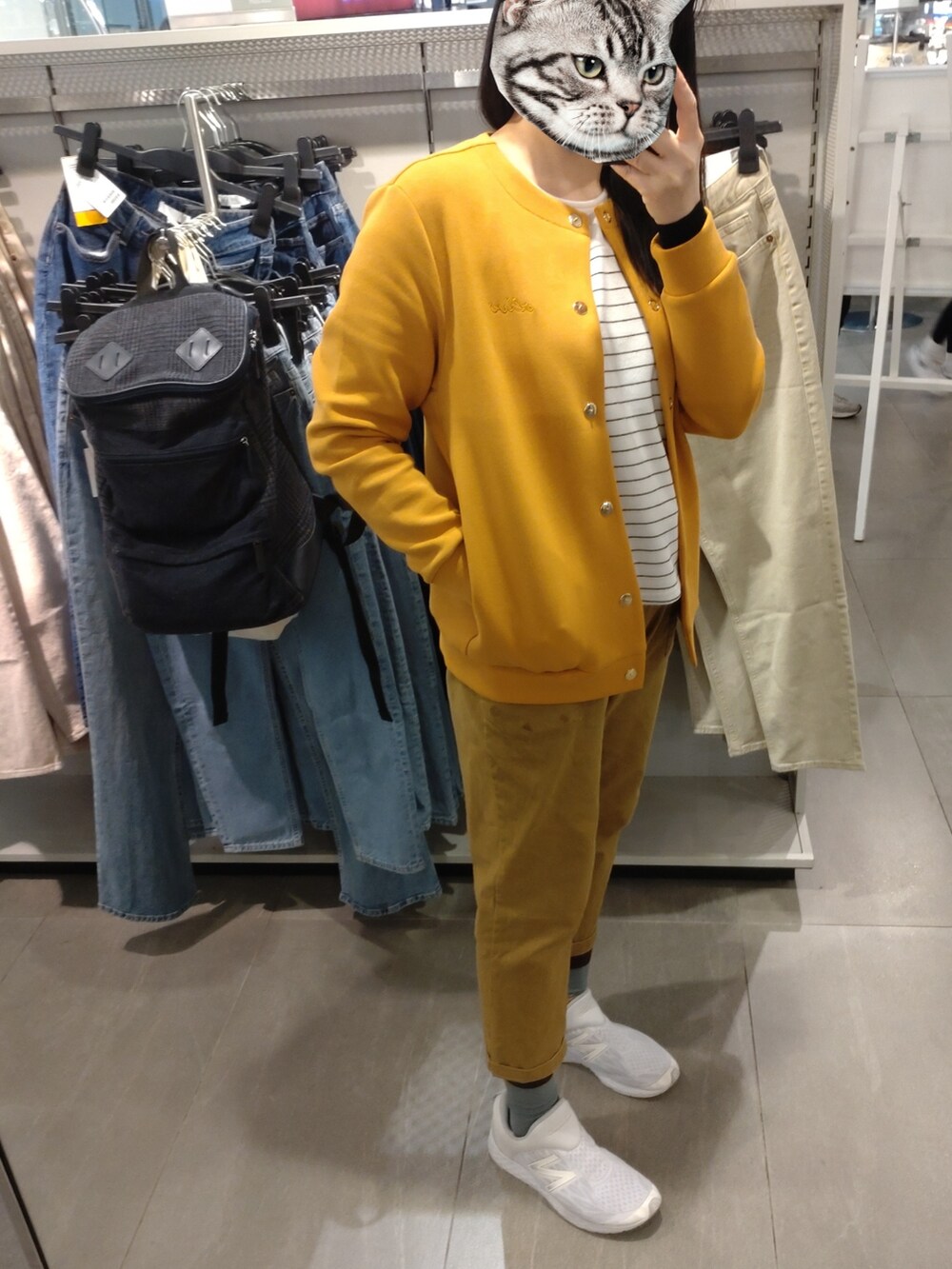 オレンジ系のジャケット/アウター、ブラウン系のチノパンツ、ホワイト系のスニーカーを着用したレディースの冬コーディネートの2枚目の写真