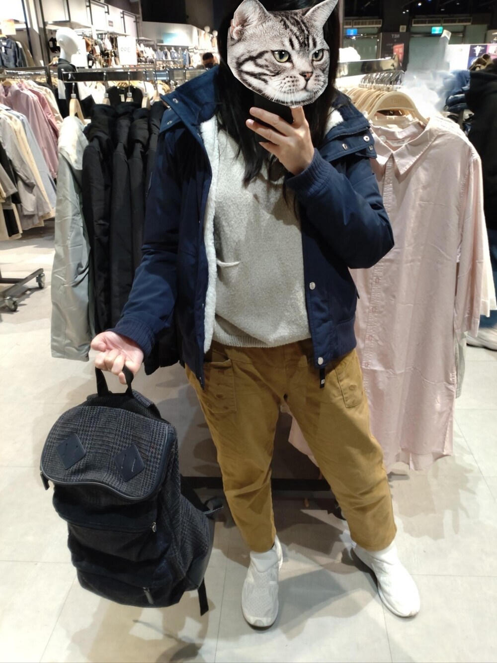 ブラウン系のチノパンツ、ブルー系のジャケット/アウター、ホワイト系のスニーカーを着用したレディースの冬コーディネートの2枚目の写真