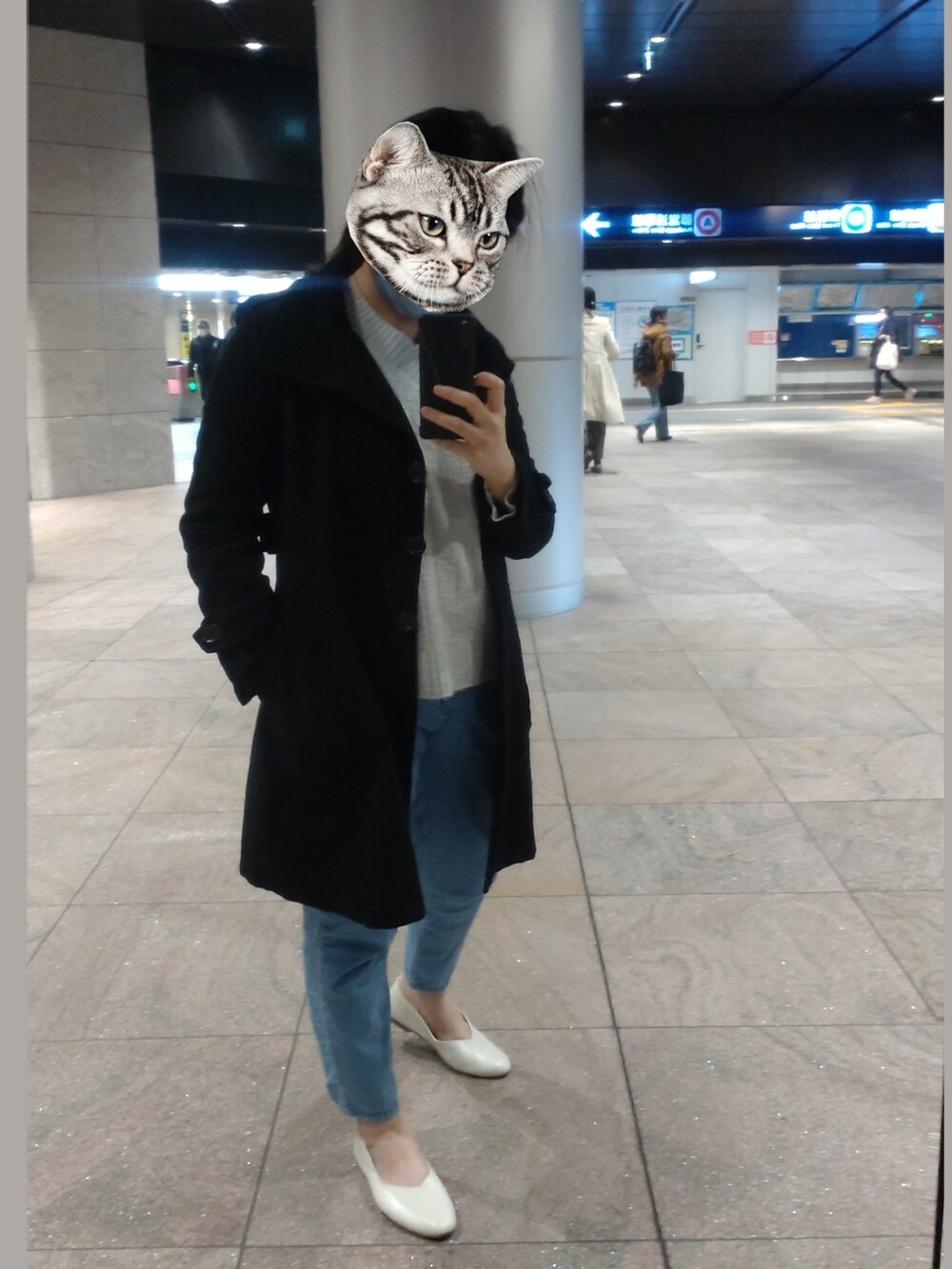 ホワイト系のシューズ、ブラック系のチェスターコートを着用したレディースの春コーディネートの2枚目の写真