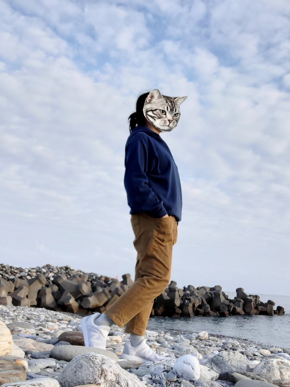 ブルー系のパーカー、ブラウン系のチノパンツ、ホワイト系のスニーカーを着用したレディースの冬コーディネートの2枚目の写真