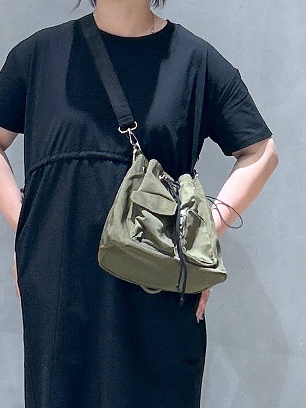 ブラック系のサンダル、グリーン系のショルダーバッグ、ブラック系のワンピースを着用したレディースの夏コーディネートの3枚目の写真